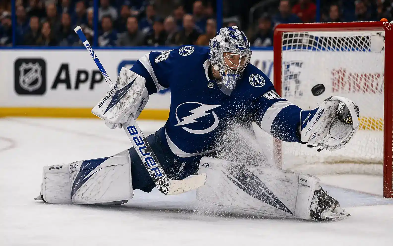Portero de hockey NHL realizando salvada de disco